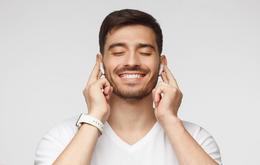 Ein Mann nutzt kabellose In-Ear-Kopfhörer.