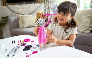 Ein Mädchen spielt mit ihrem Barbie Adventskalender