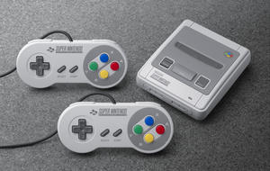 Nintendo-Konsole SNES Classic Mini mit zwei Controllern auf grauem Teppich