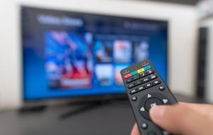 Ein TV Stick streamt verschiedene Inhalte auf den Fernseher.