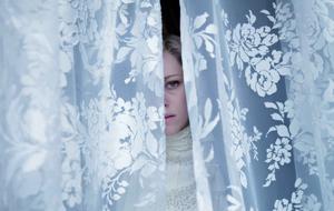 Kristen Stewart als Lady Diana blickt durch Vorhang