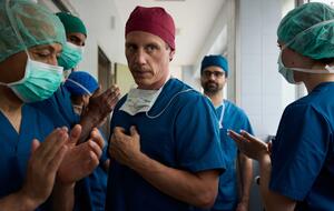 Dr. Nice in OP-Kleidung zwischen anderen Krankenhaus-Mitarbeitern