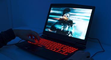 Ein Mann spielt auf einem Gaming-Laptop.