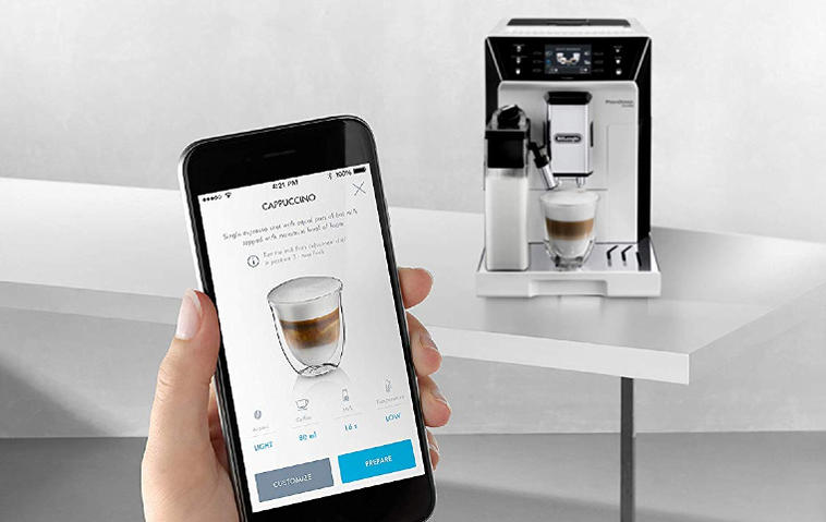 Jemand bedient seine smarte Kaffeemaschine per App