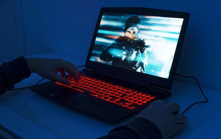 Ein Mann spielt auf einem Gaming-Laptop.