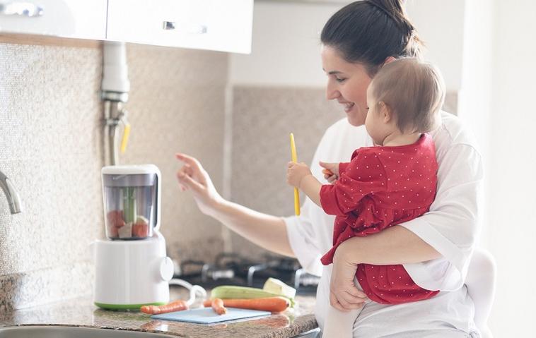 Frau nutzt Mixer für Babynahrung