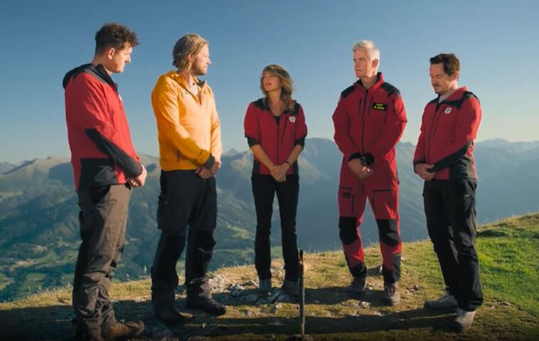 Die Bergretter stehen auf einem Bergkamm und beratschlagen sich